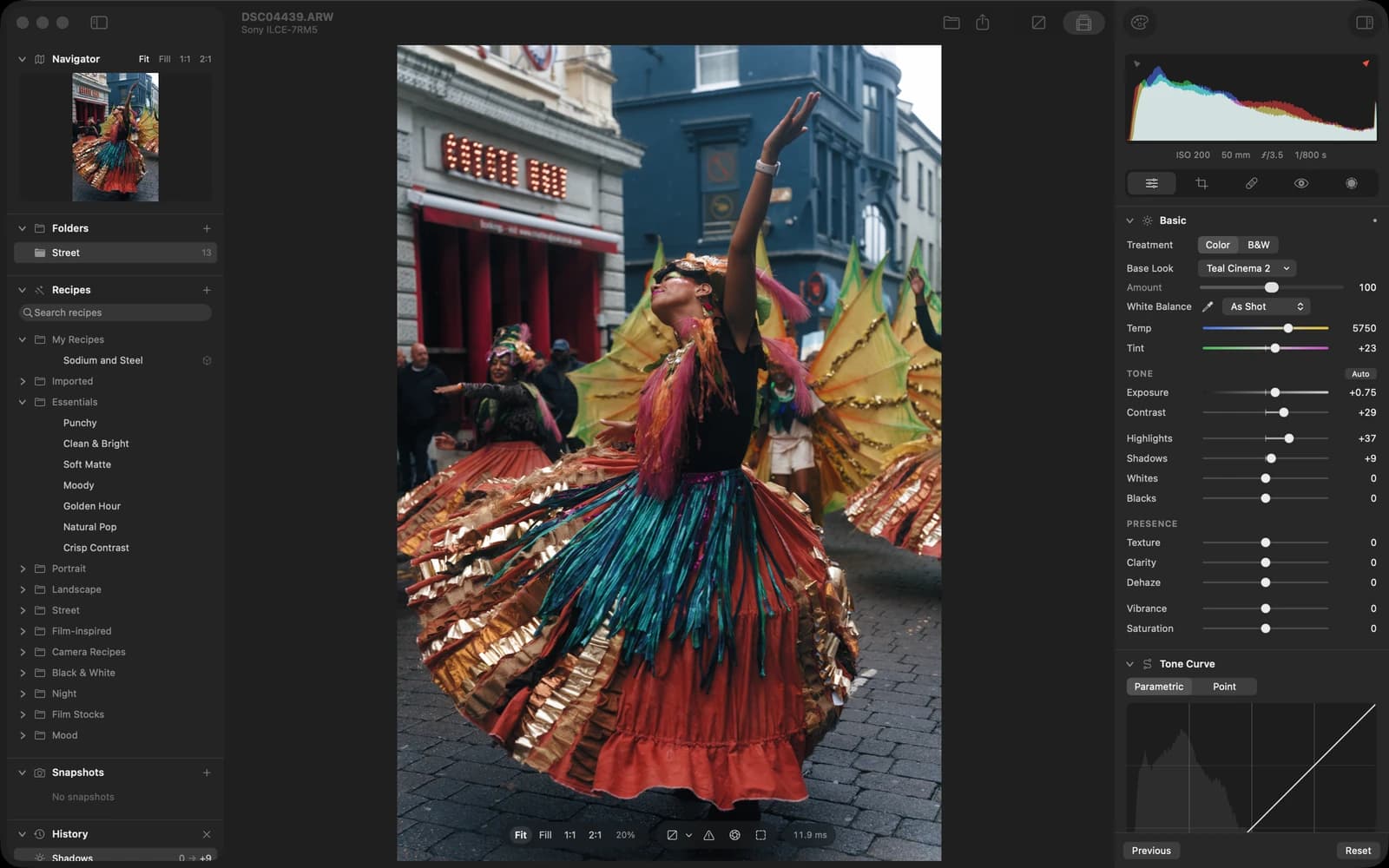 Redlamp's Develop workspace: a raw photo of a carnival dancer in a swirling skirt in the middle, folders and recipes on the left, the histogram and the Basic and Tone Curve panels on the right